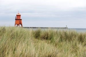 Roter Leuchtturm mit der Nordmole im Hintergrund