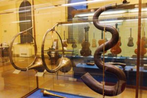 Rechts ein schlangenartiges Blasinstrument von ca. 1800
