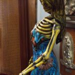 Statue eines weiblichen Skeletts mit langen Haaren und einem bunten Kleid