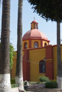 rot-gelbe Kirche unter Palmen