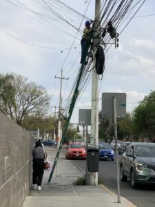 Mann auf einer Leiter arbeitet an Stromkabeln