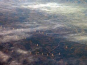 Blick aus dem Flugzeug auf eine große Windfarm 