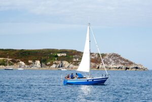 Ein Segler verlässt den Hafen von Camaret sur Mer