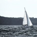 Ein Segler kämpft sich mit gerefftem Groß durch den Seegang