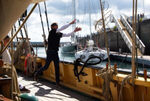 Das Festmachen im Hafen ist sehr aufwändig, da der Platz zum Drehen sehr beschränkt ist. Hier wirft ein Crewmitglied eine Wurfleine zum Steg. An der Wurfleine ist die eigentliche dicke Festmacherleine befestigt.